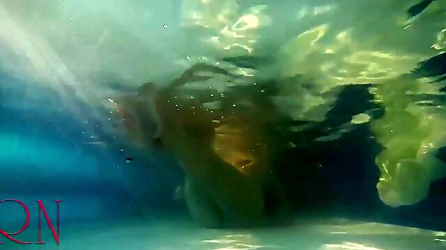 Elegant and supple sweetheart, swimming underwater in the outdoor swimming pool. three two